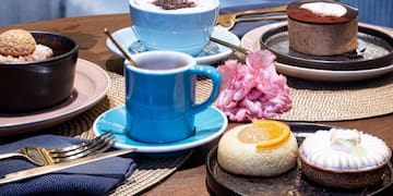 a table with plates of food and cups of coffee