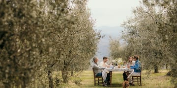 a group of people sitting at a table in a field
