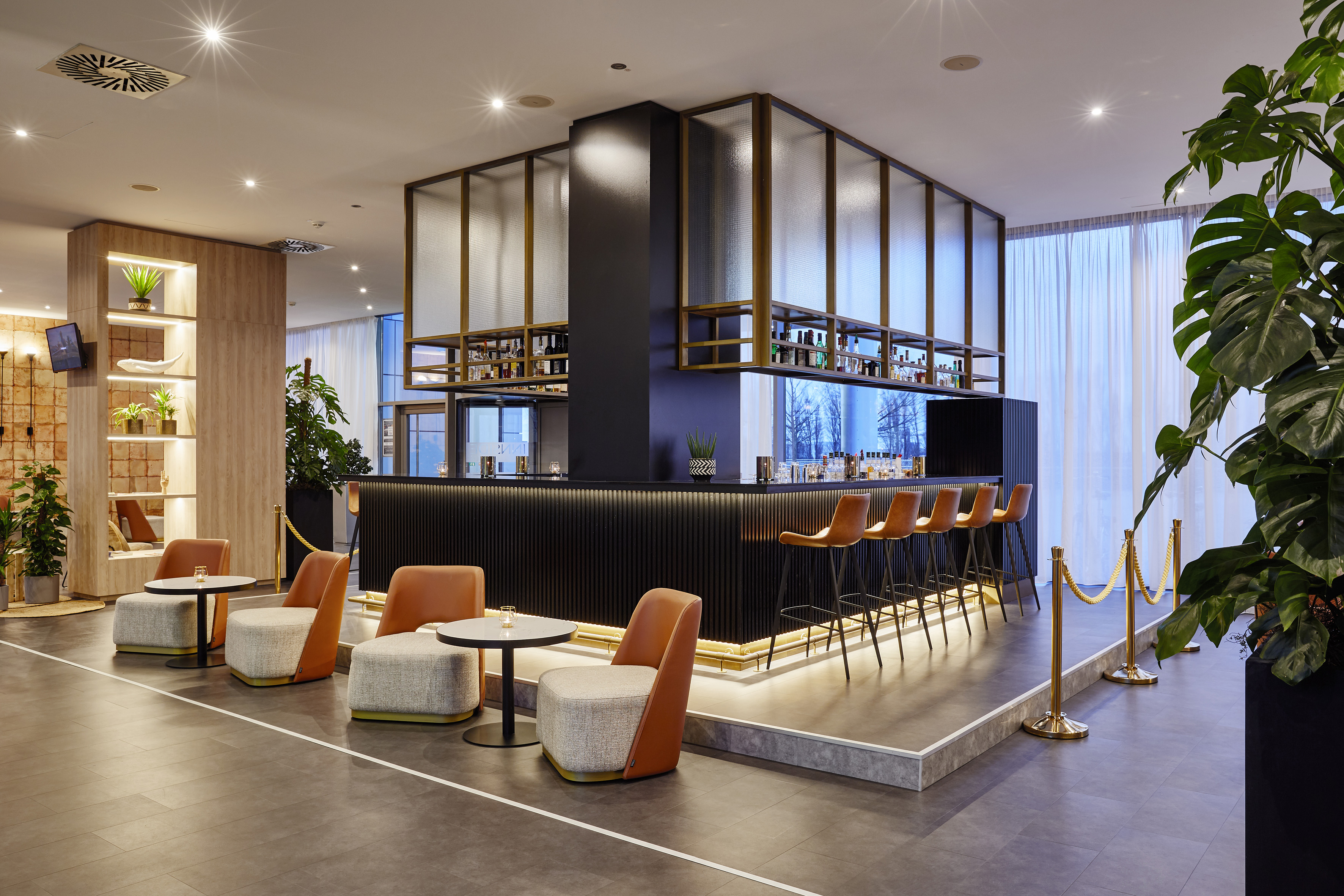Modern hotel bar lounge with dark counter, high stools, and stylish seating.