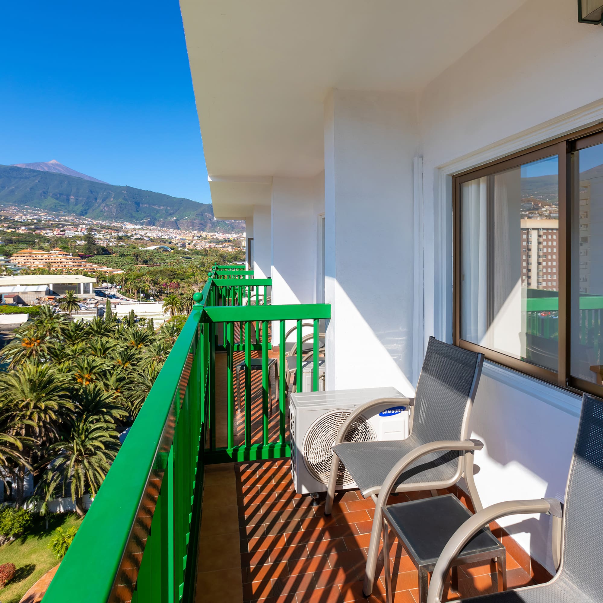 a balcony with chairs and a table and chairs on it