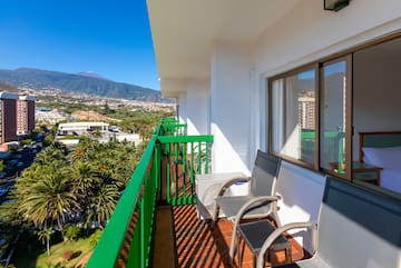 a balcony with chairs and a table and chairs on it