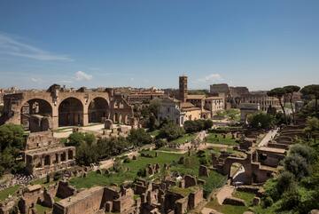 an old city with ruins with Roman Forum in the background