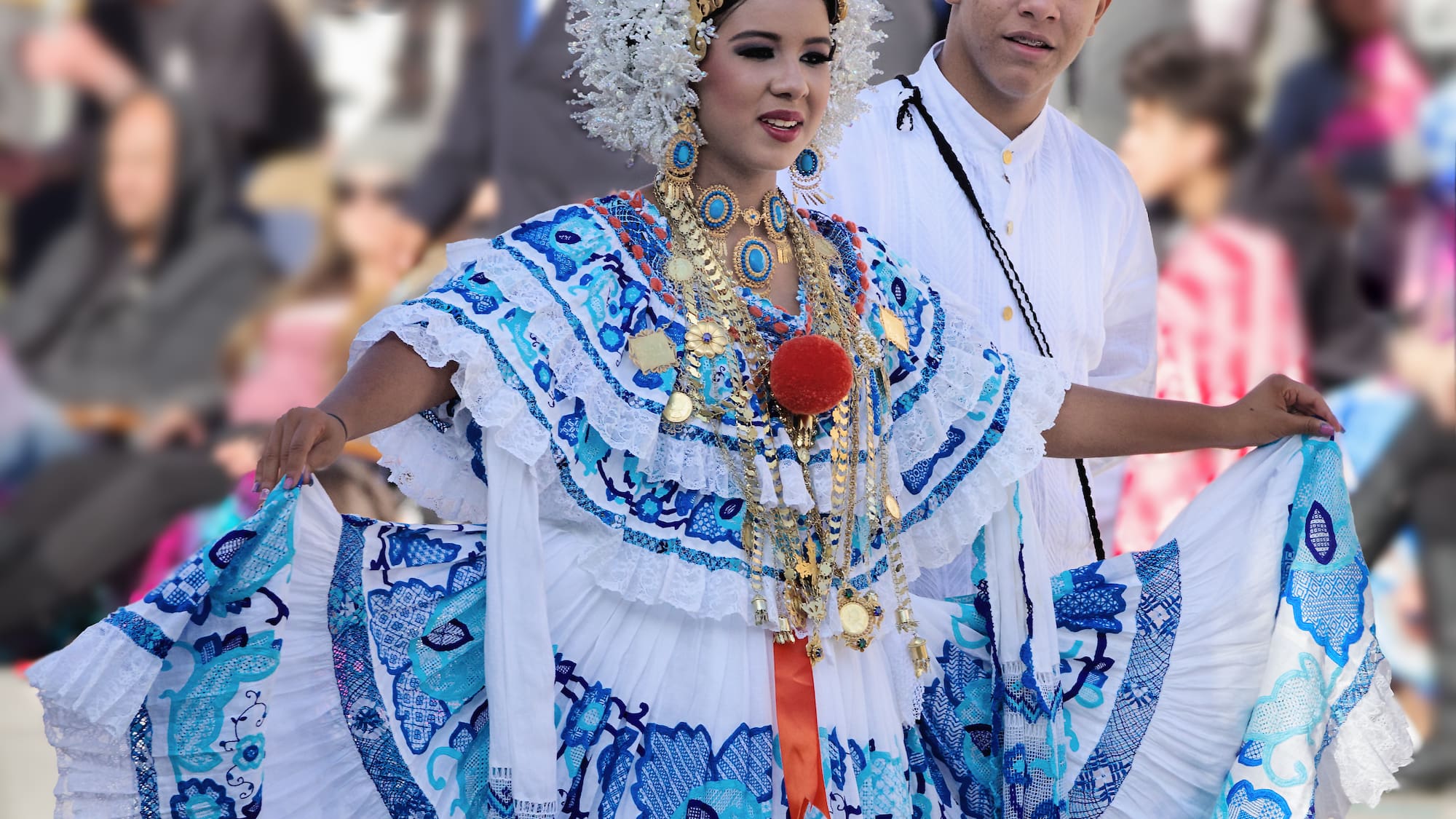 a woman in a blue and white dress with a man in a white hat
