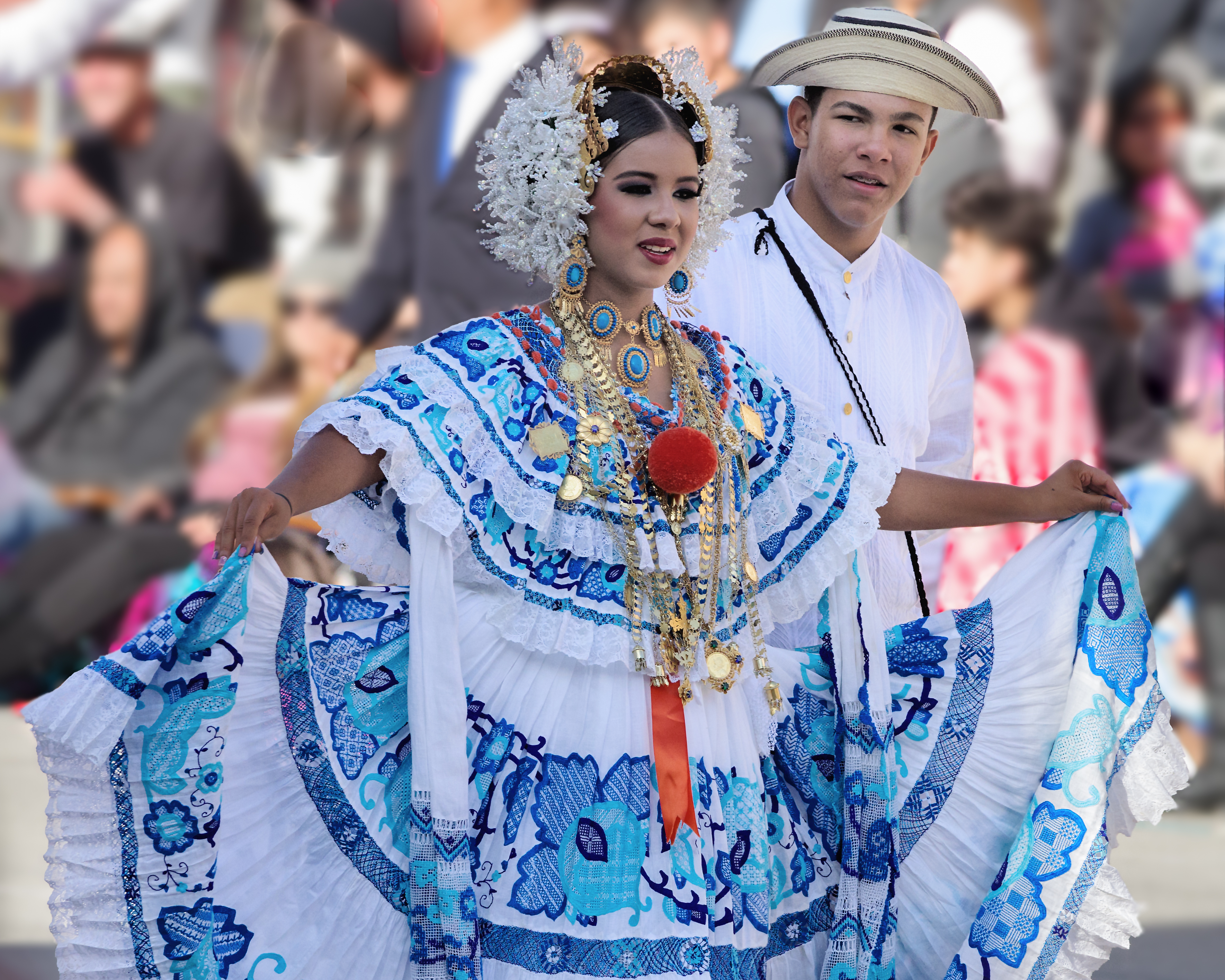 a woman in a blue and white dress with a man in a white hat