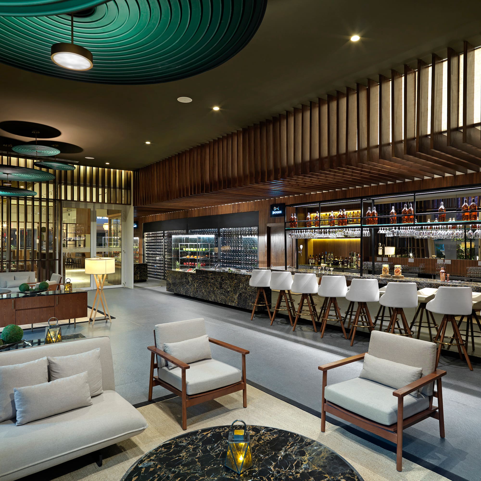 Modern luxury hotel bar lounge with wine display, marble counter, and stylish seating.