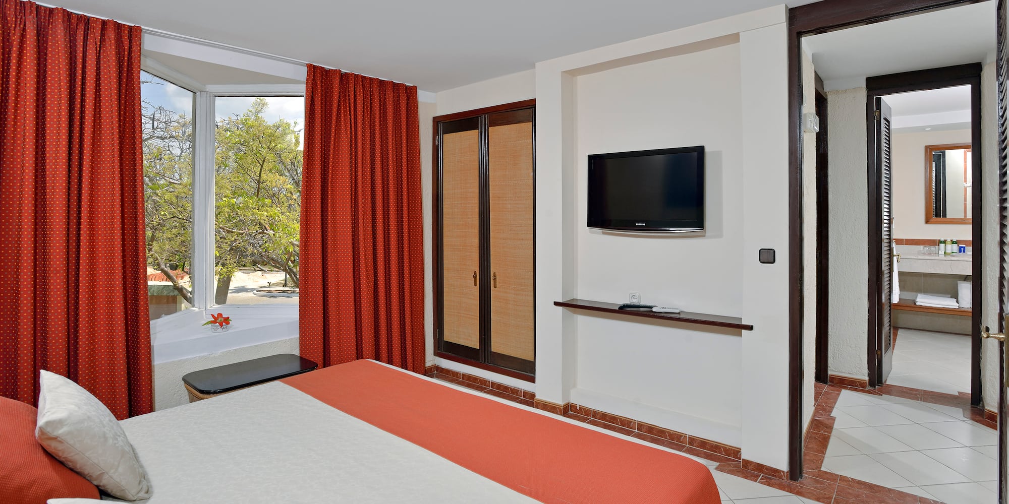 a room with a bed and a television