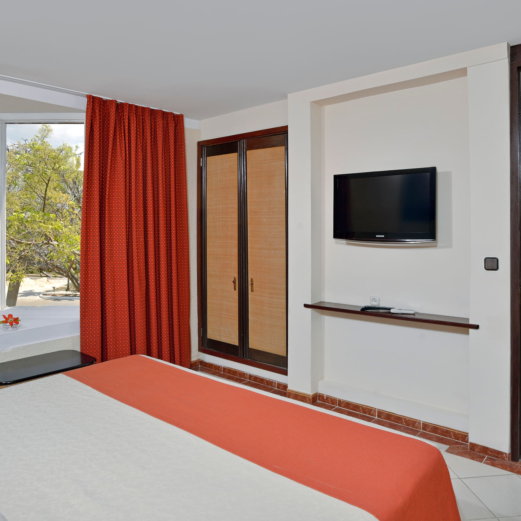 a room with a bed and a television