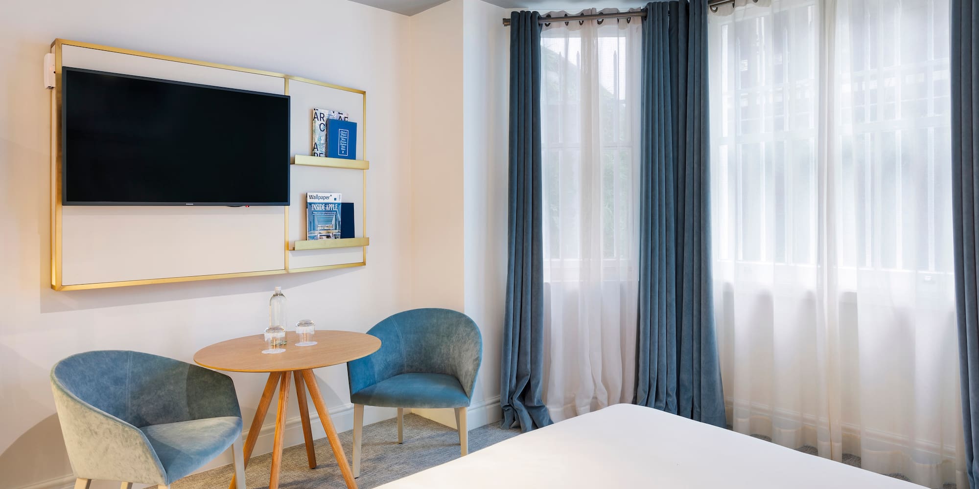 a room with a bed and a table and chairs