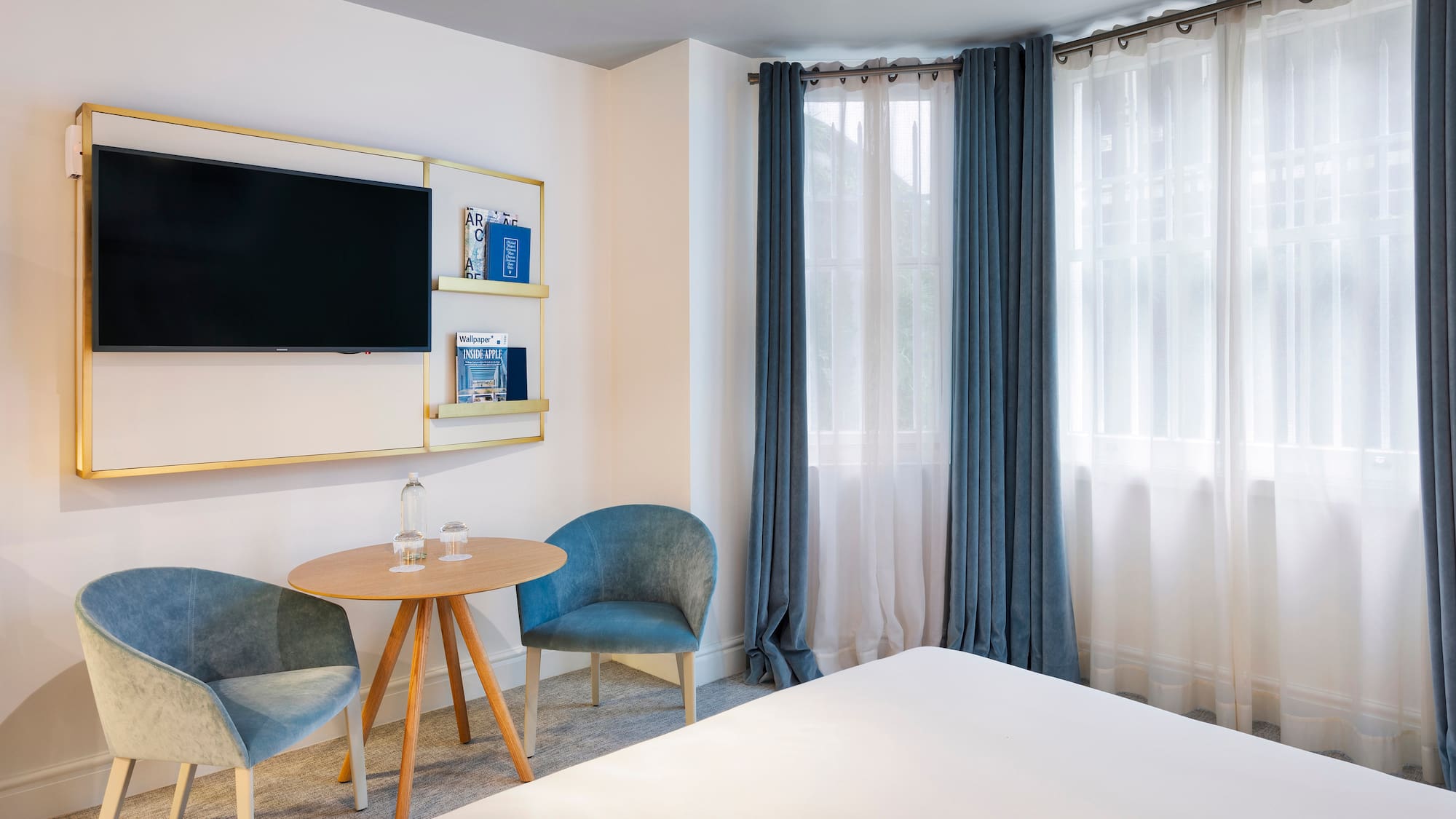 a room with a bed and a table and chairs