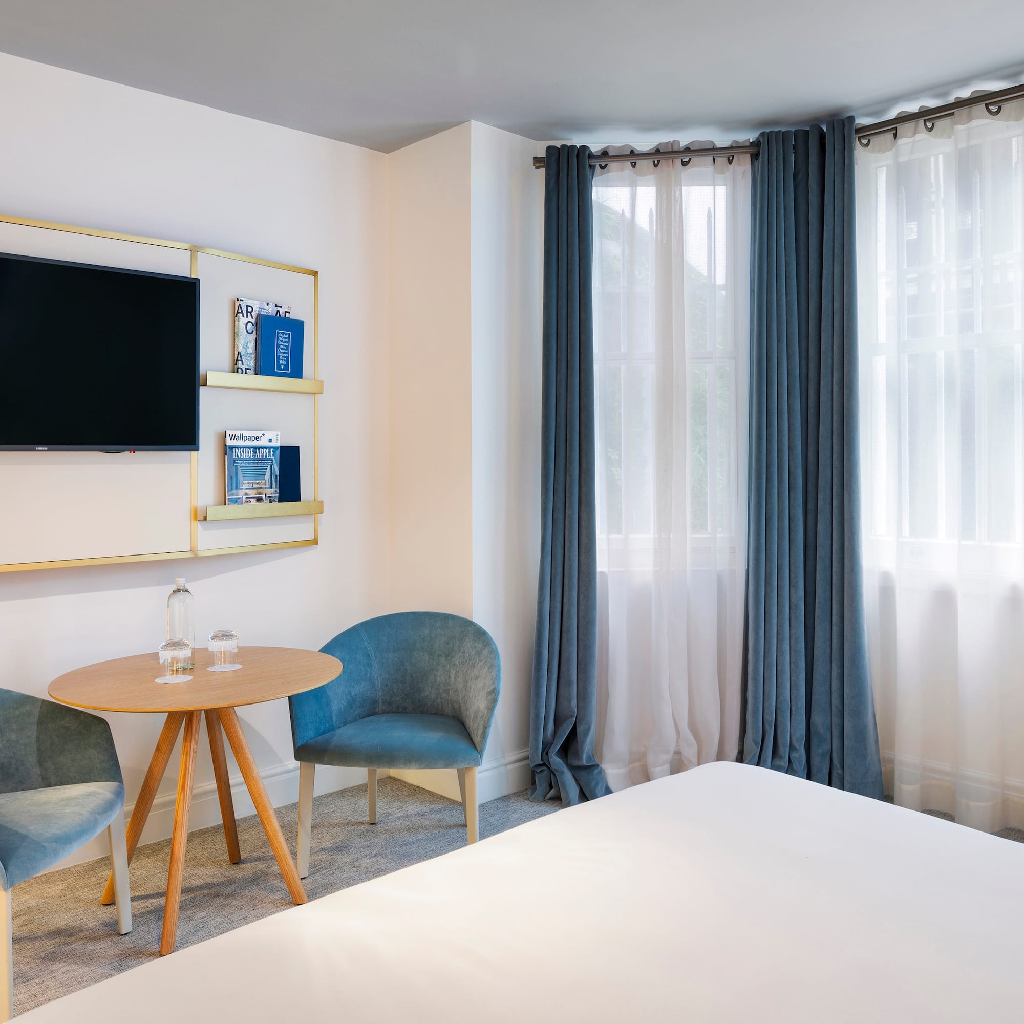 a room with a bed and a table and chairs