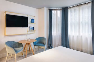 a room with a bed and a table and chairs