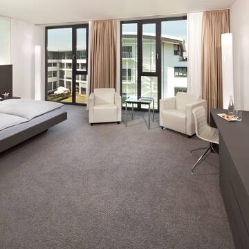 a room with a bed and chairs