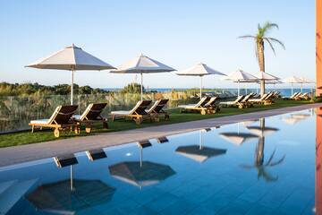a pool with chairs and umbrellas