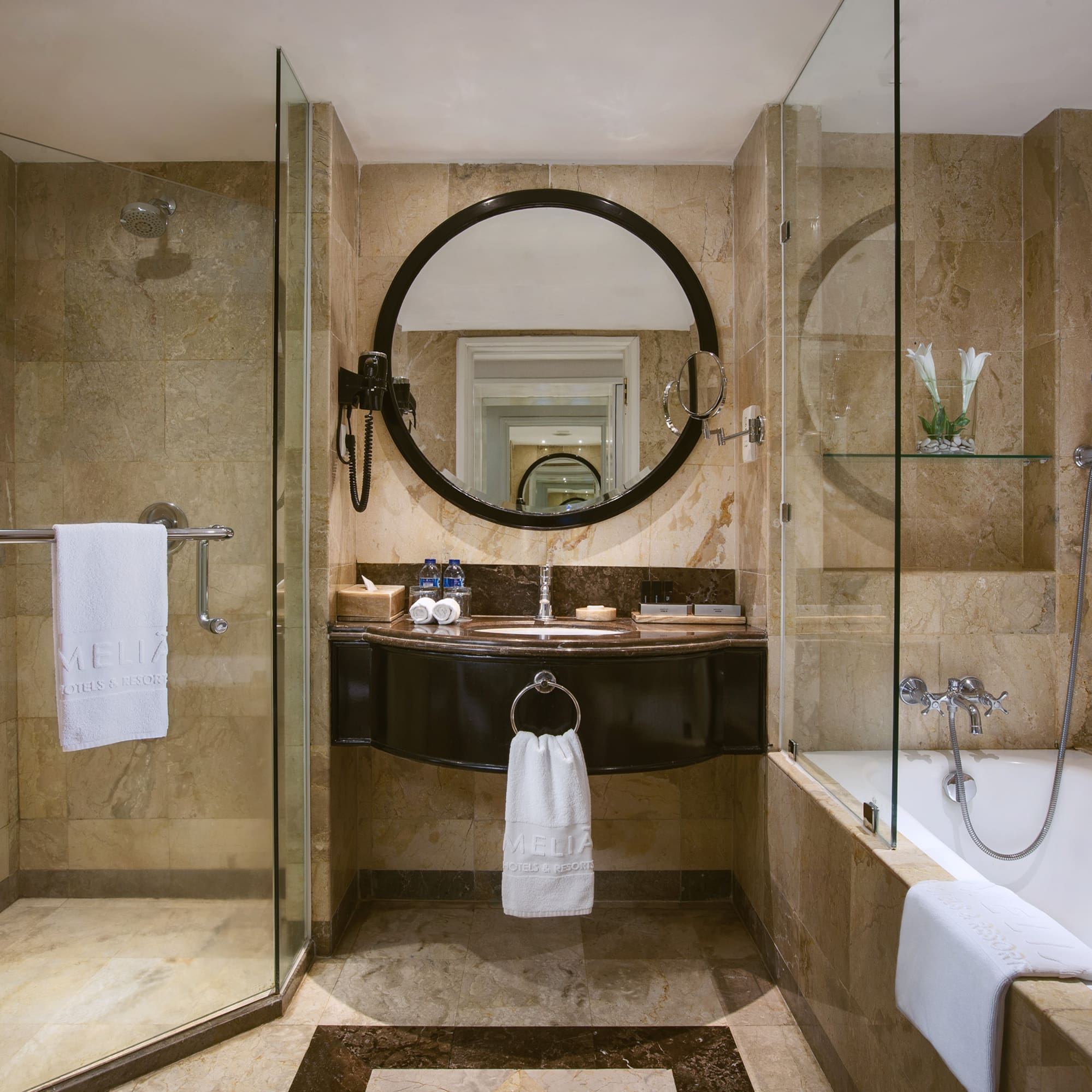 a bathroom with a round mirror and a tub