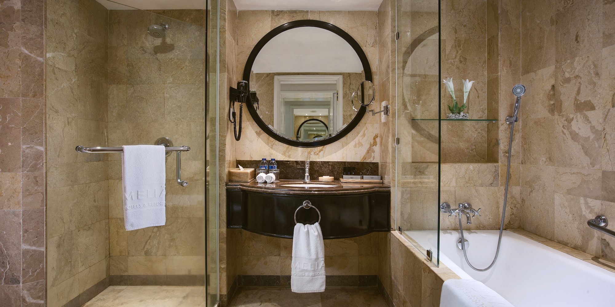a bathroom with a round mirror and a tub