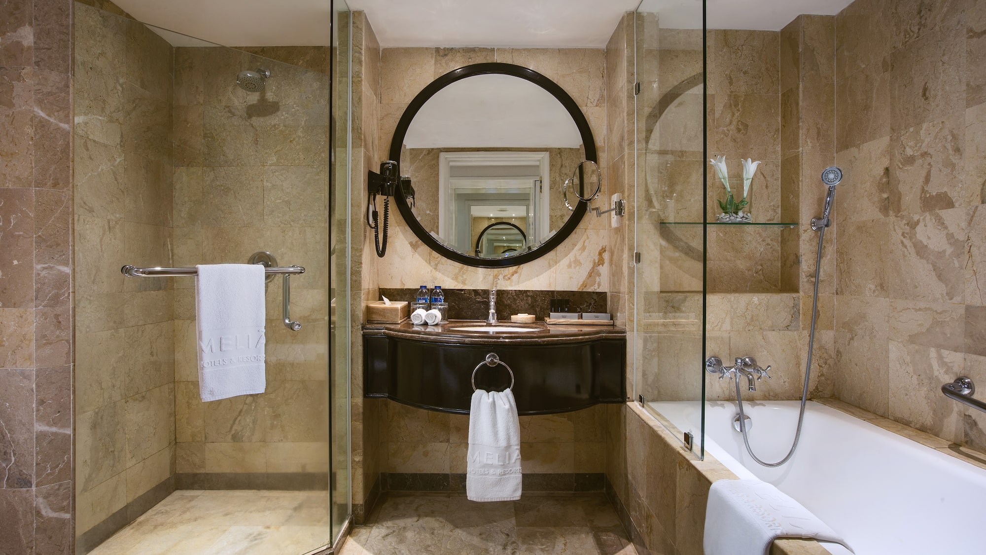 a bathroom with a round mirror and a tub