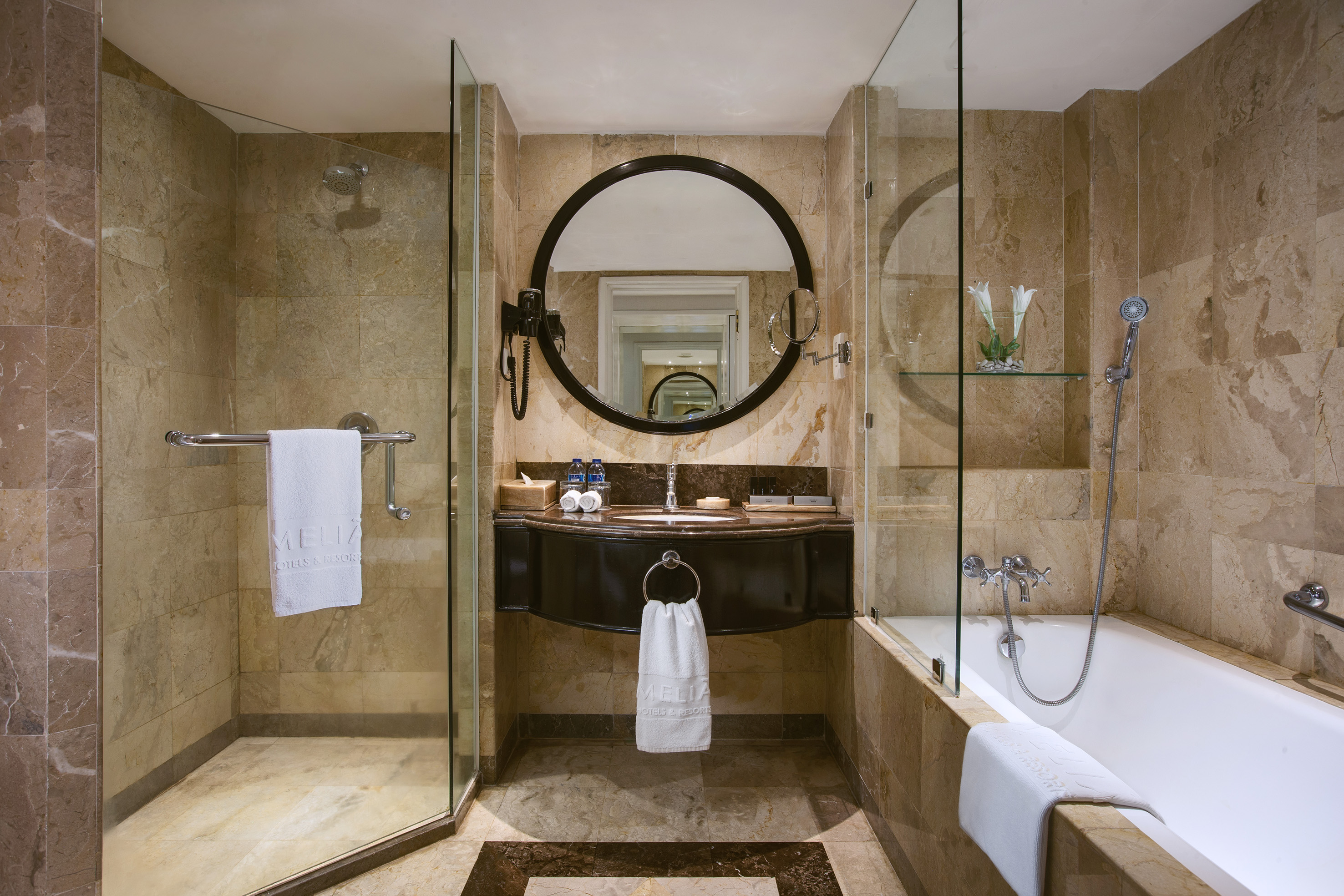 a bathroom with a round mirror and a tub
