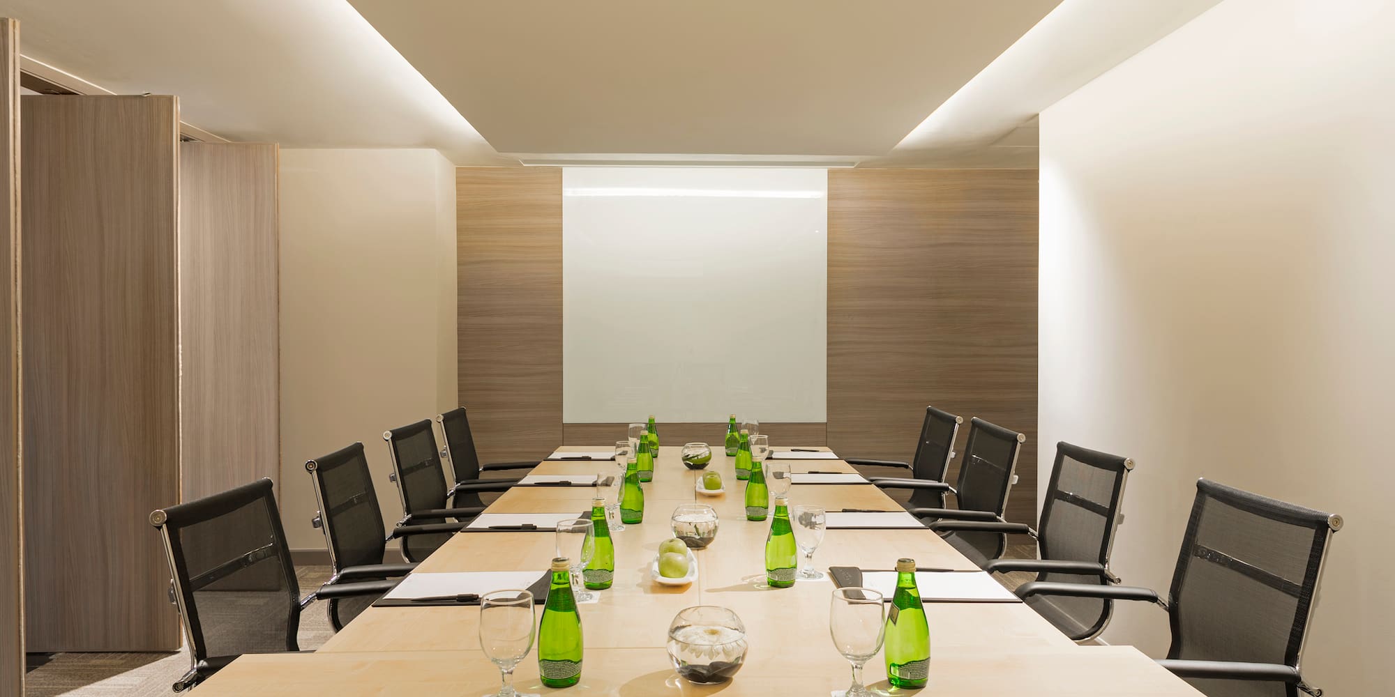 a conference room with a table with green bottles and chairs