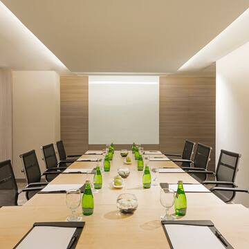 a conference room with a table with green bottles and chairs