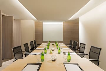 a conference room with a table with green bottles and chairs