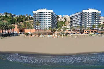 a beach with buildings and palm trees