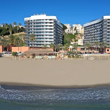 a beach with buildings and palm trees