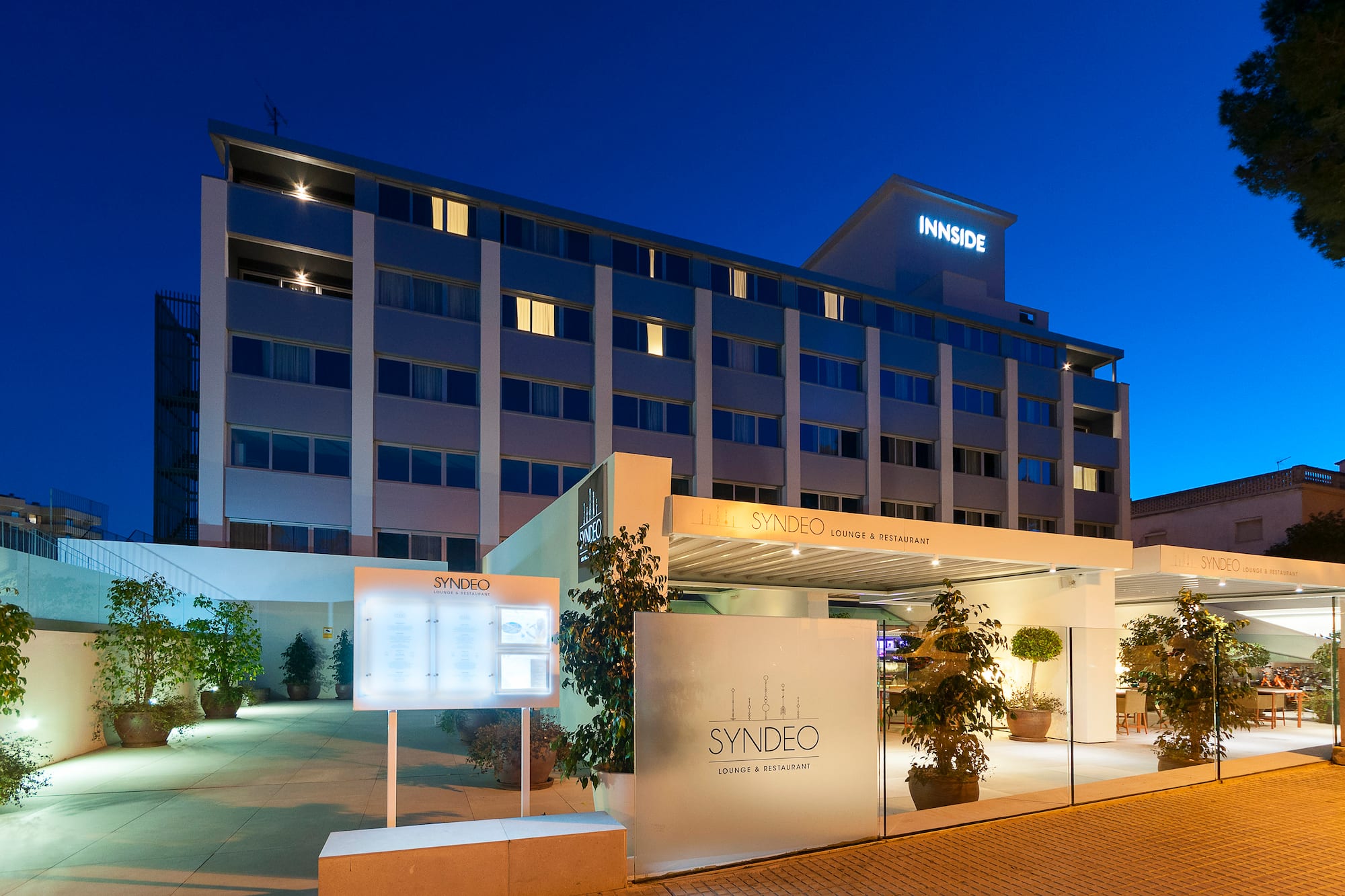 Innside hotel and Syndeo lounge & restaurant exterior, illuminated at night.