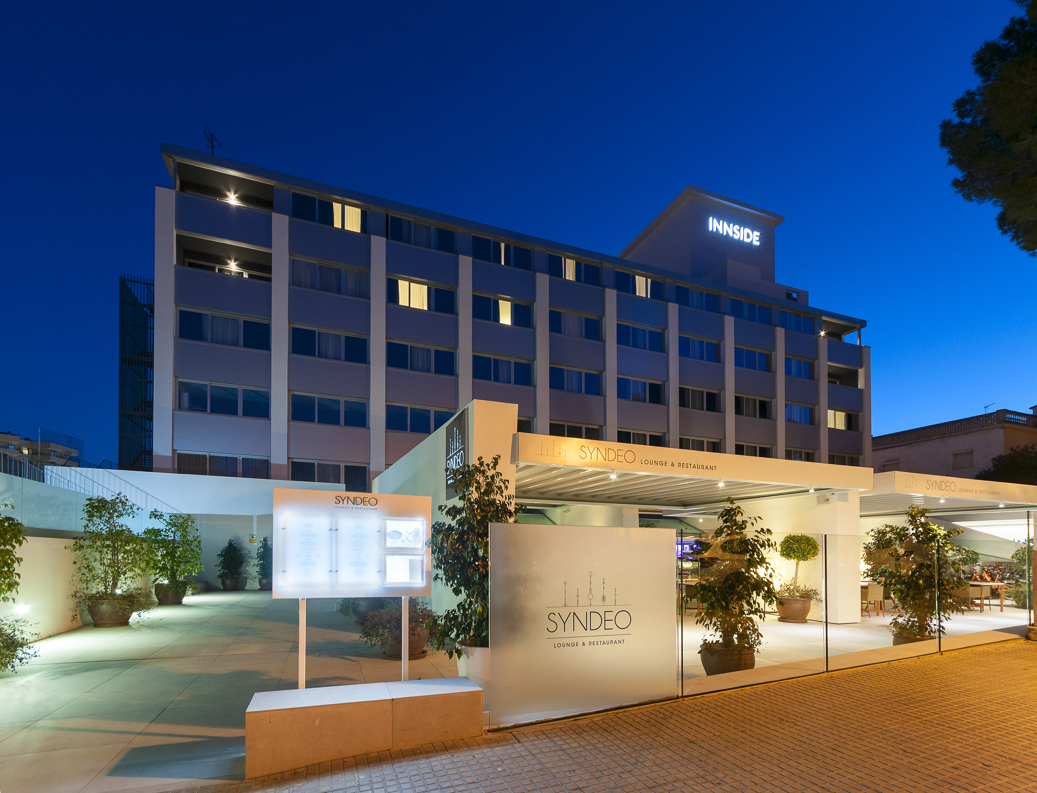 Innside hotel and Syndeo lounge & restaurant exterior, illuminated at night.