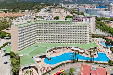 a large building with a pool and a city in the background