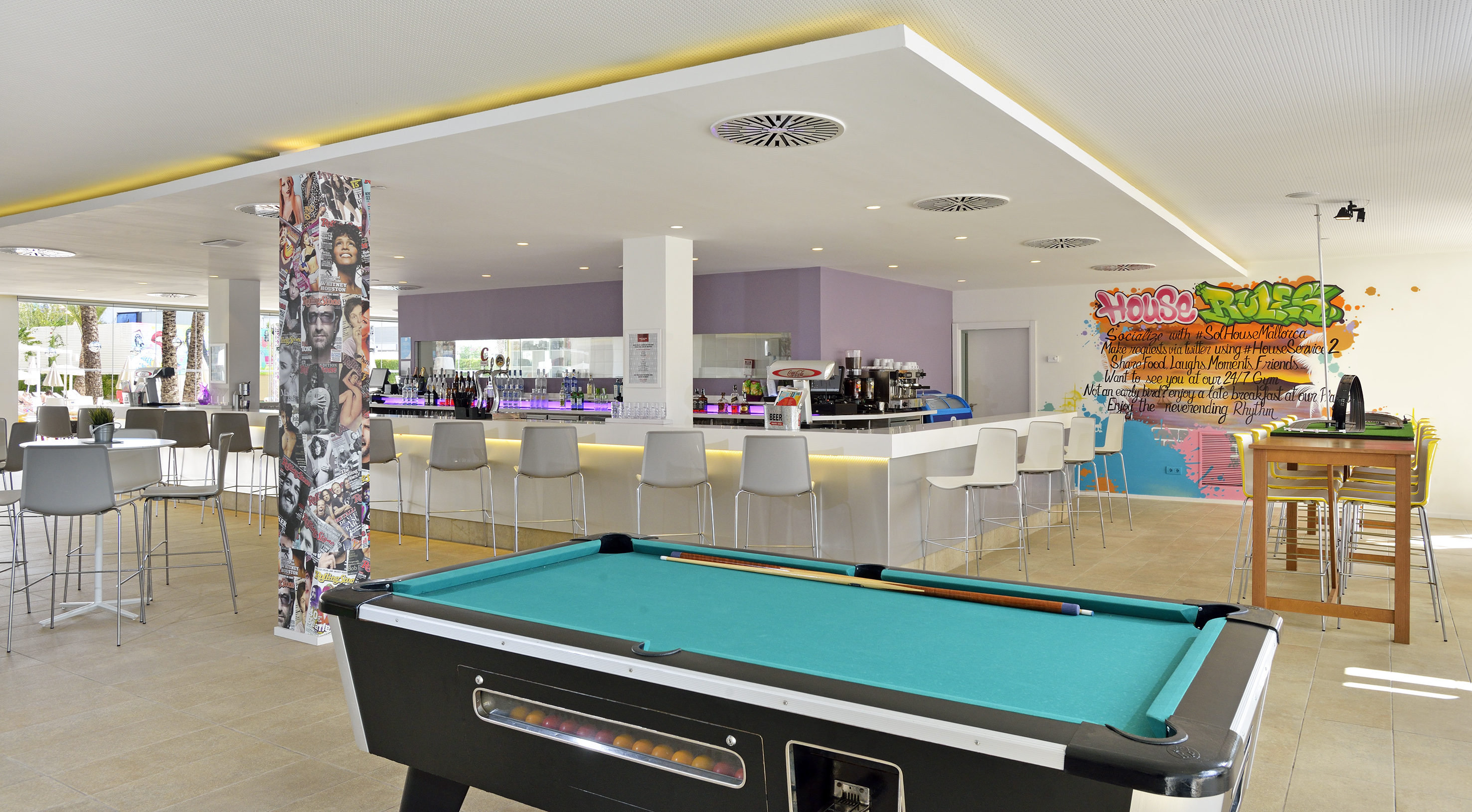Sol House Mallorca bar with pool table, modern decor, and vibrant graffiti.
