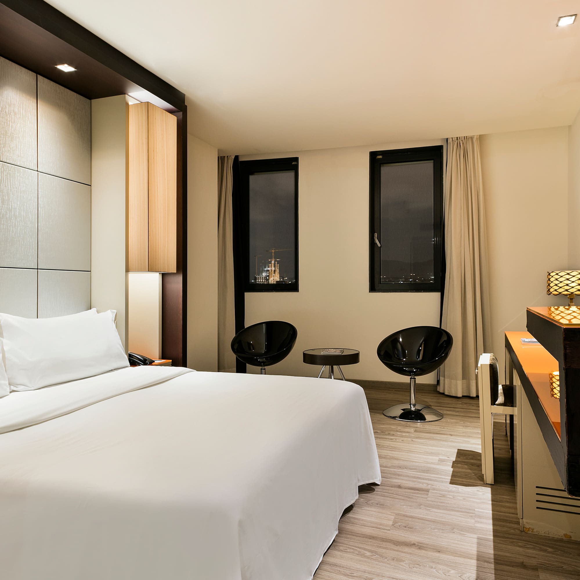 a room with a bed and chairs