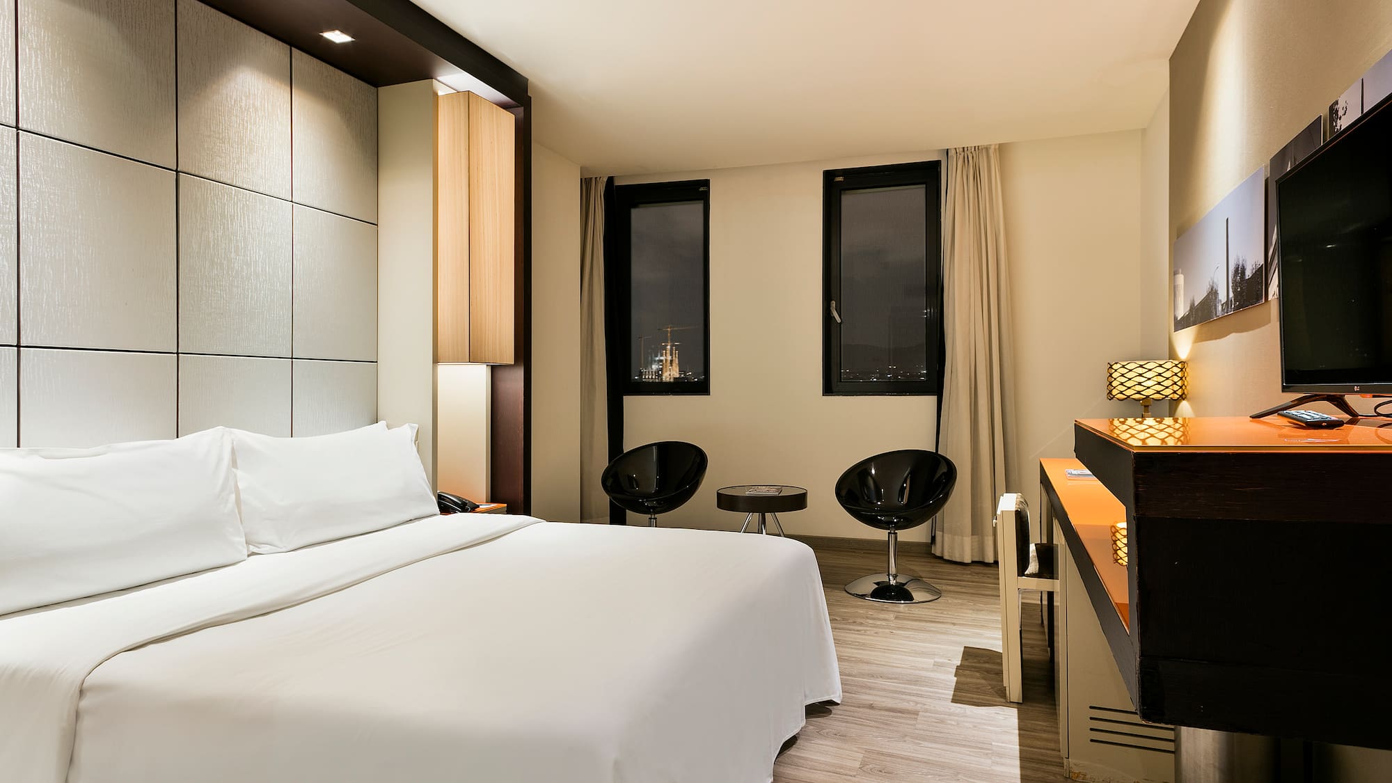 a room with a bed and chairs