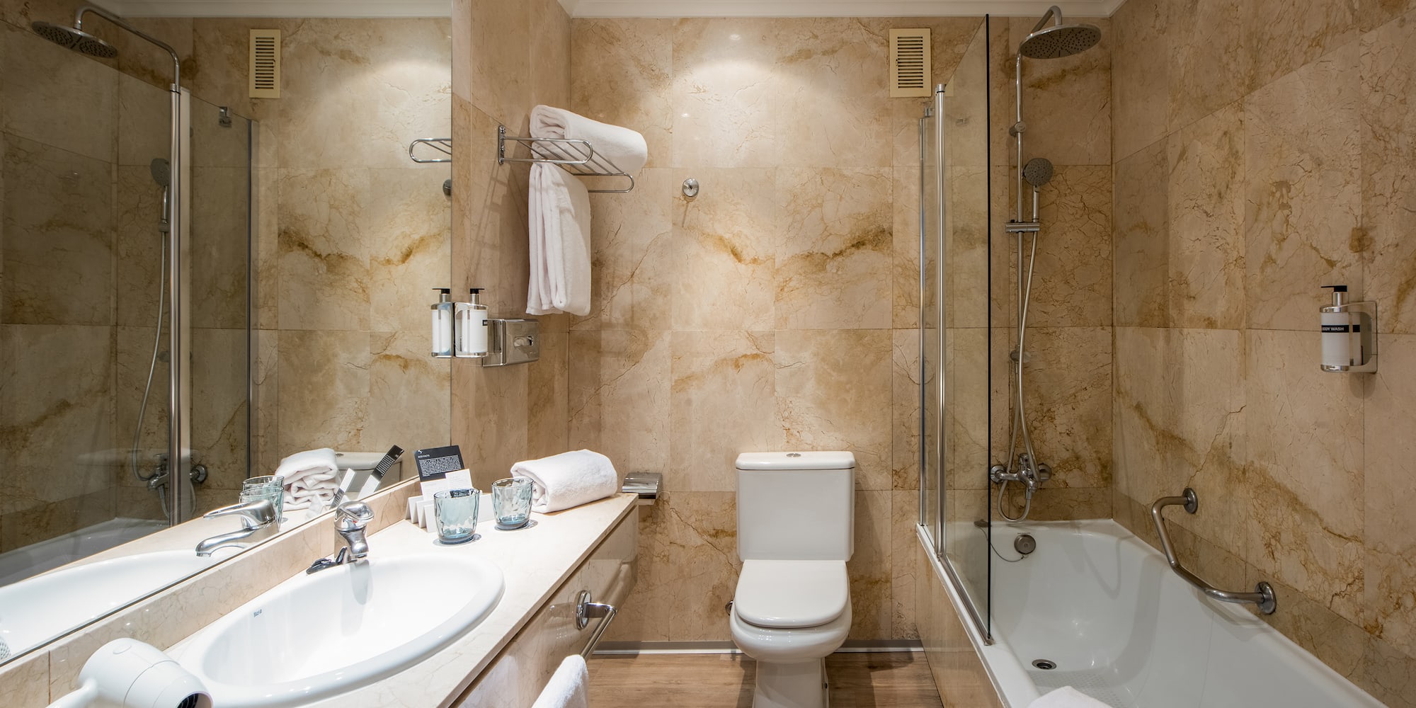 a bathroom with marble walls and a toilet and tub