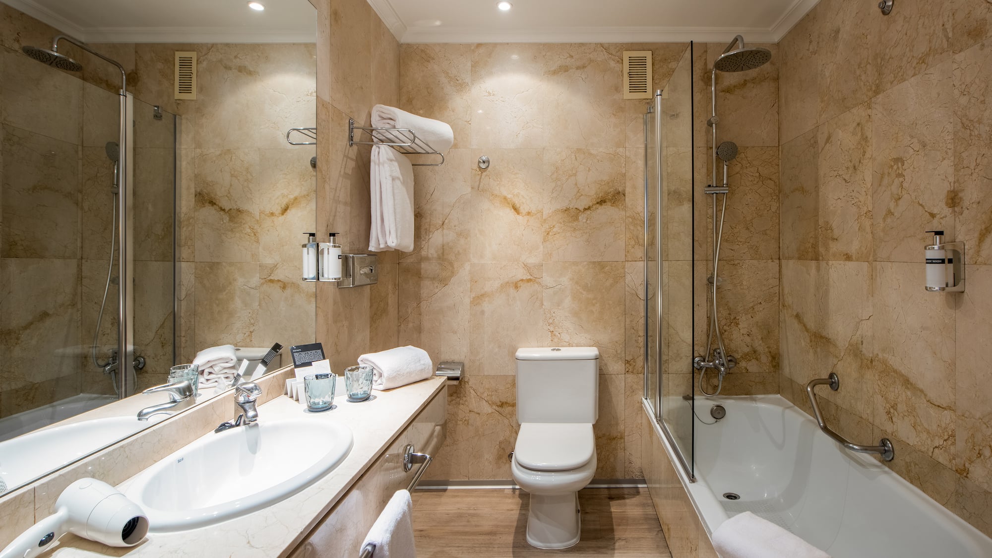 a bathroom with marble walls and a toilet and tub