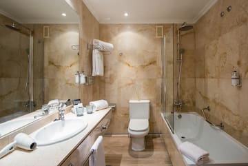 a bathroom with marble walls and a toilet and tub