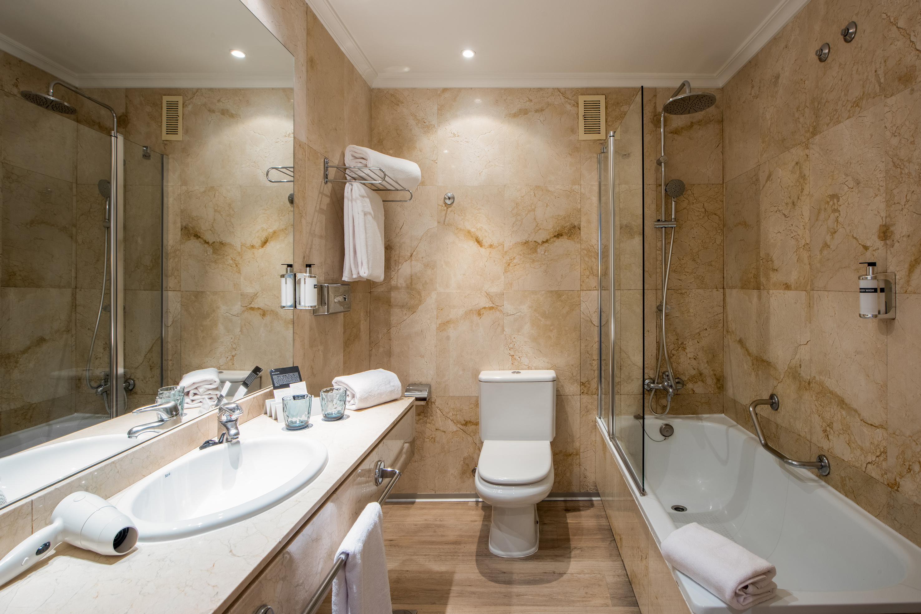 a bathroom with marble walls and a toilet and tub