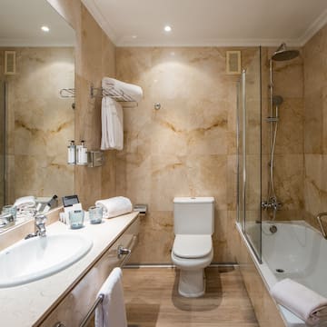 a bathroom with marble walls and a toilet and tub