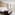 Modern hotel room with twin beds, city view, light wood floor, and bright decor.