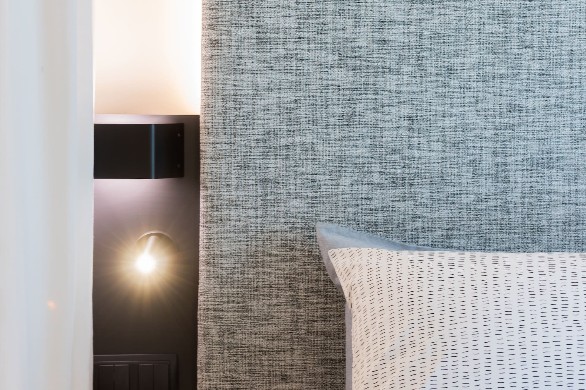 a coffee cup on a table next to a bed