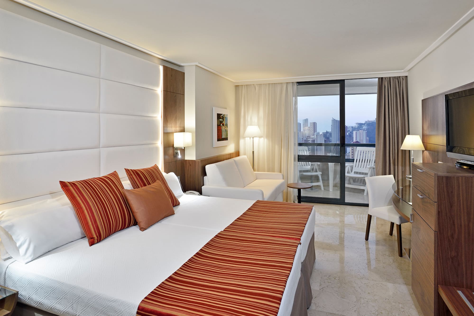 a hotel room with a bed and chairs