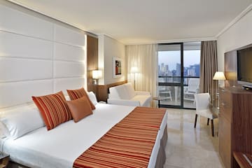 a hotel room with a bed and chairs