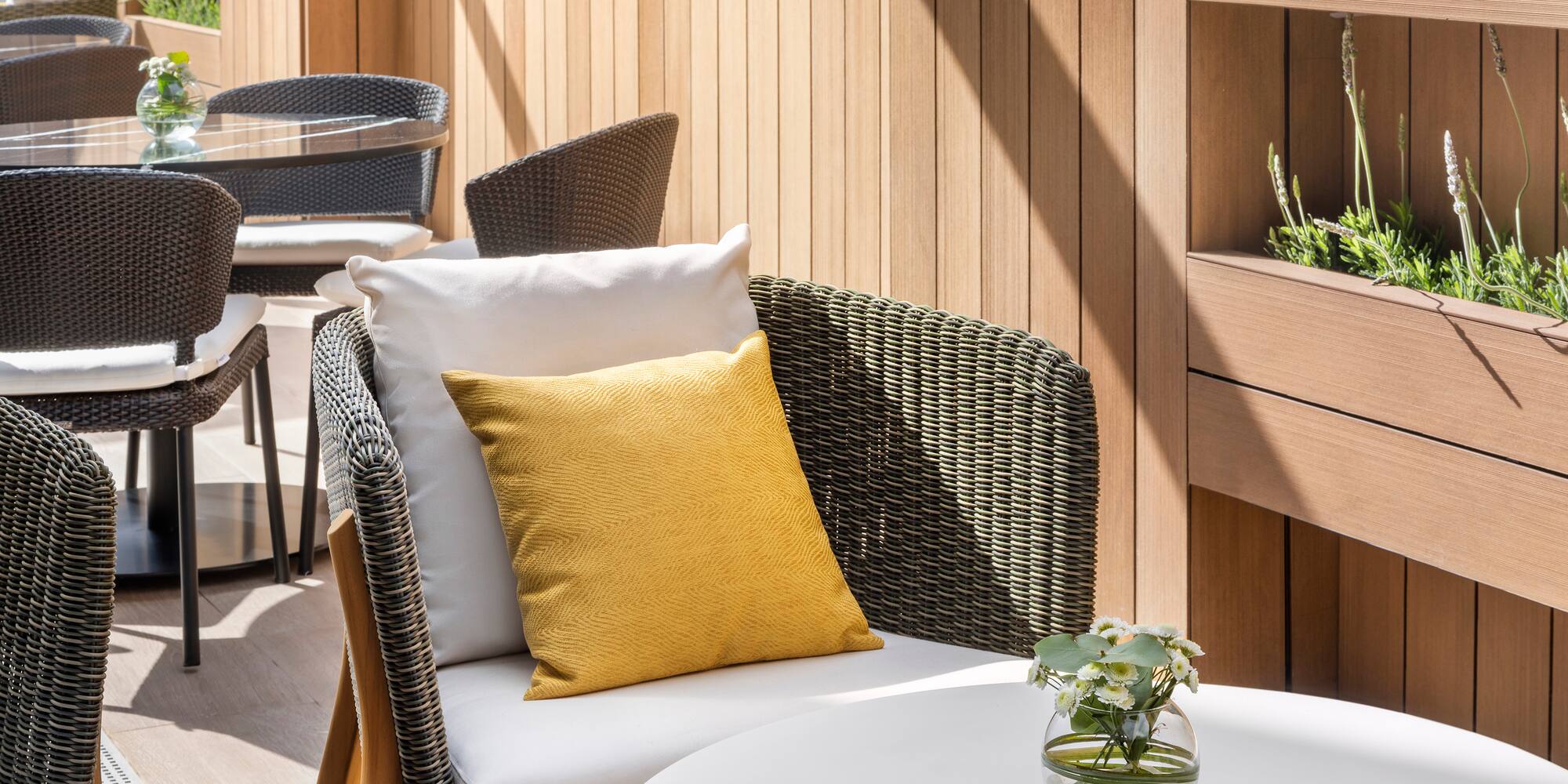 a chair and table with a yellow pillow