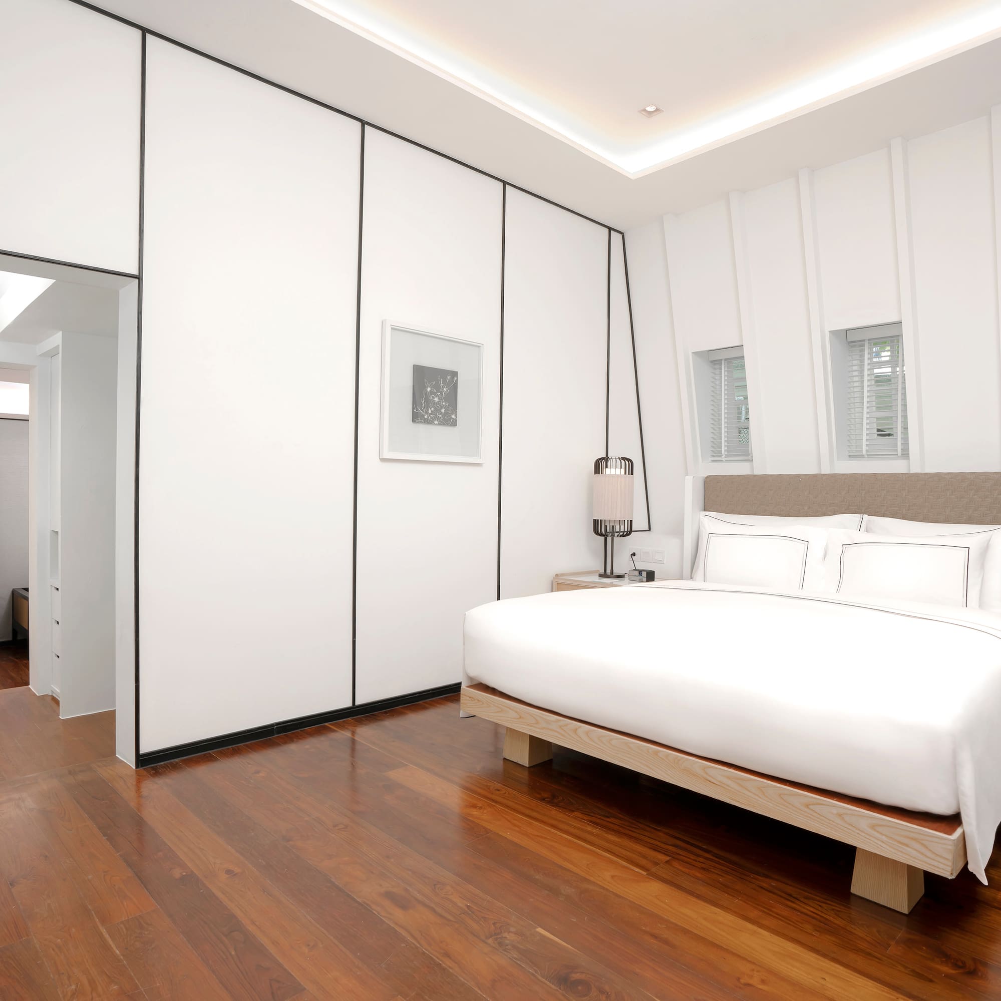 a bedroom with a wood floor and a bed