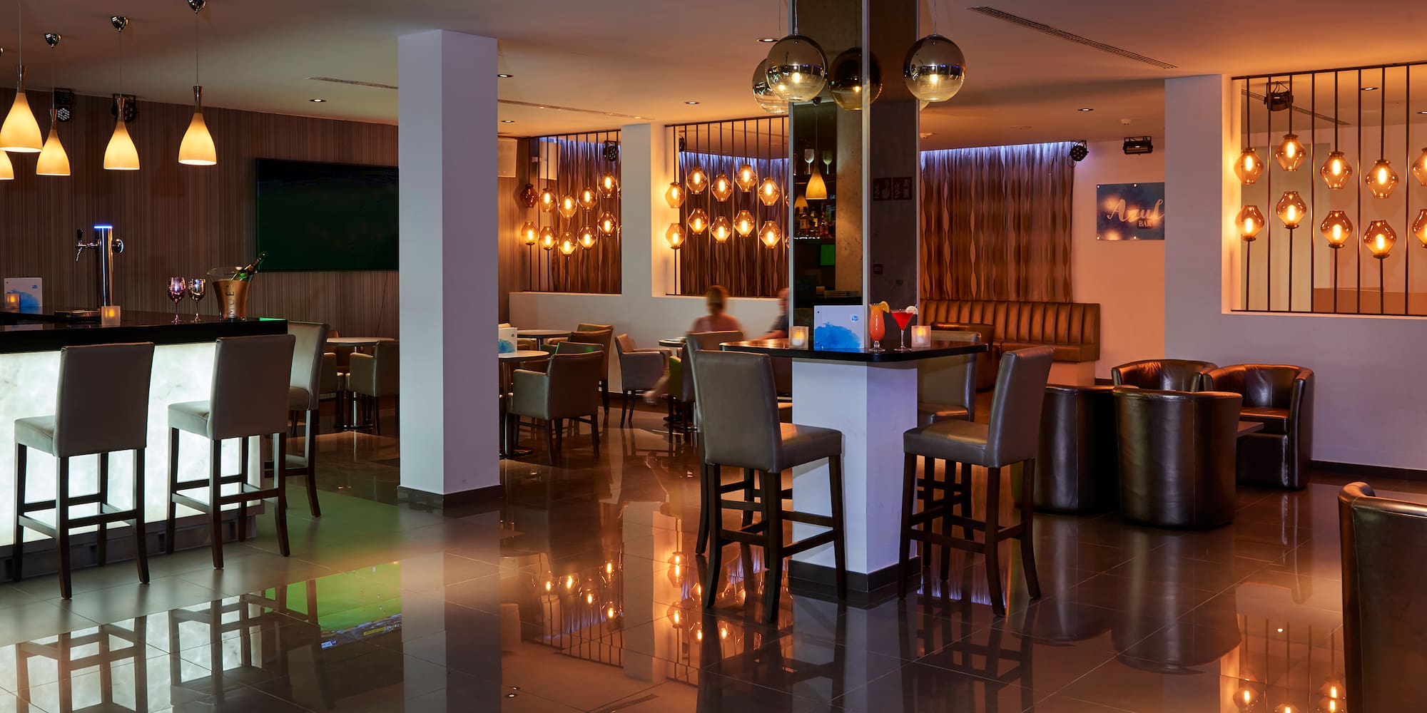 a room with a bar and chairs