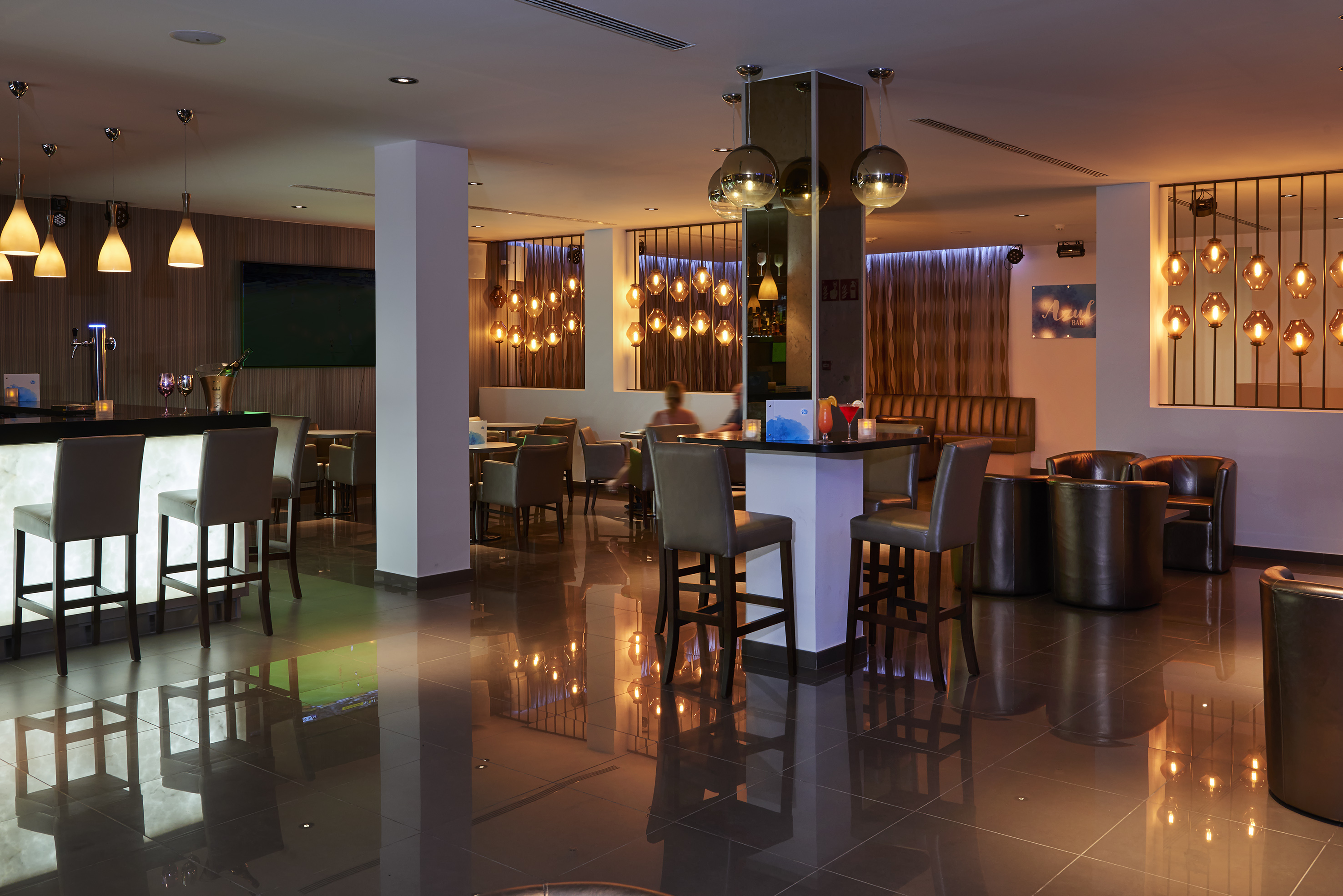 a room with a bar and chairs