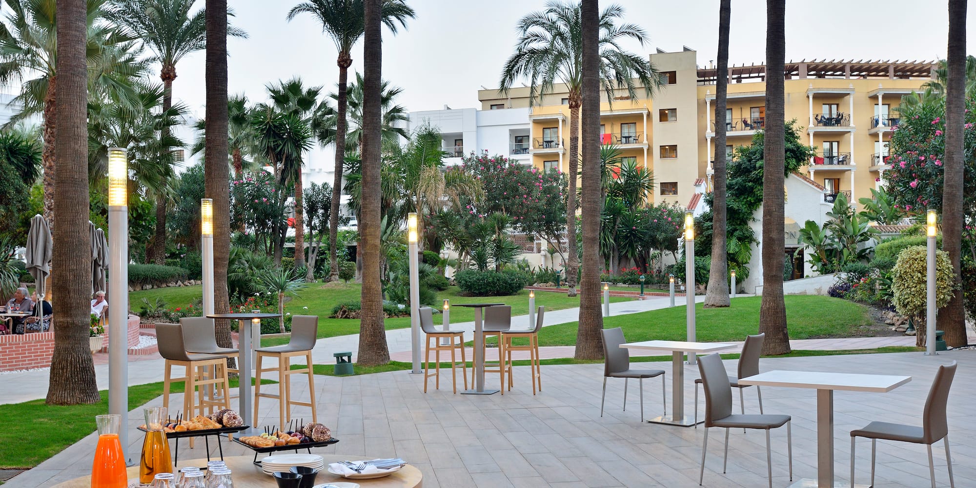 a patio with tables and chairs and trees