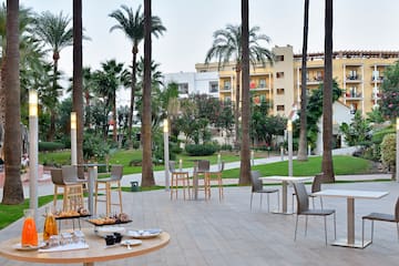 a patio with tables and chairs and trees