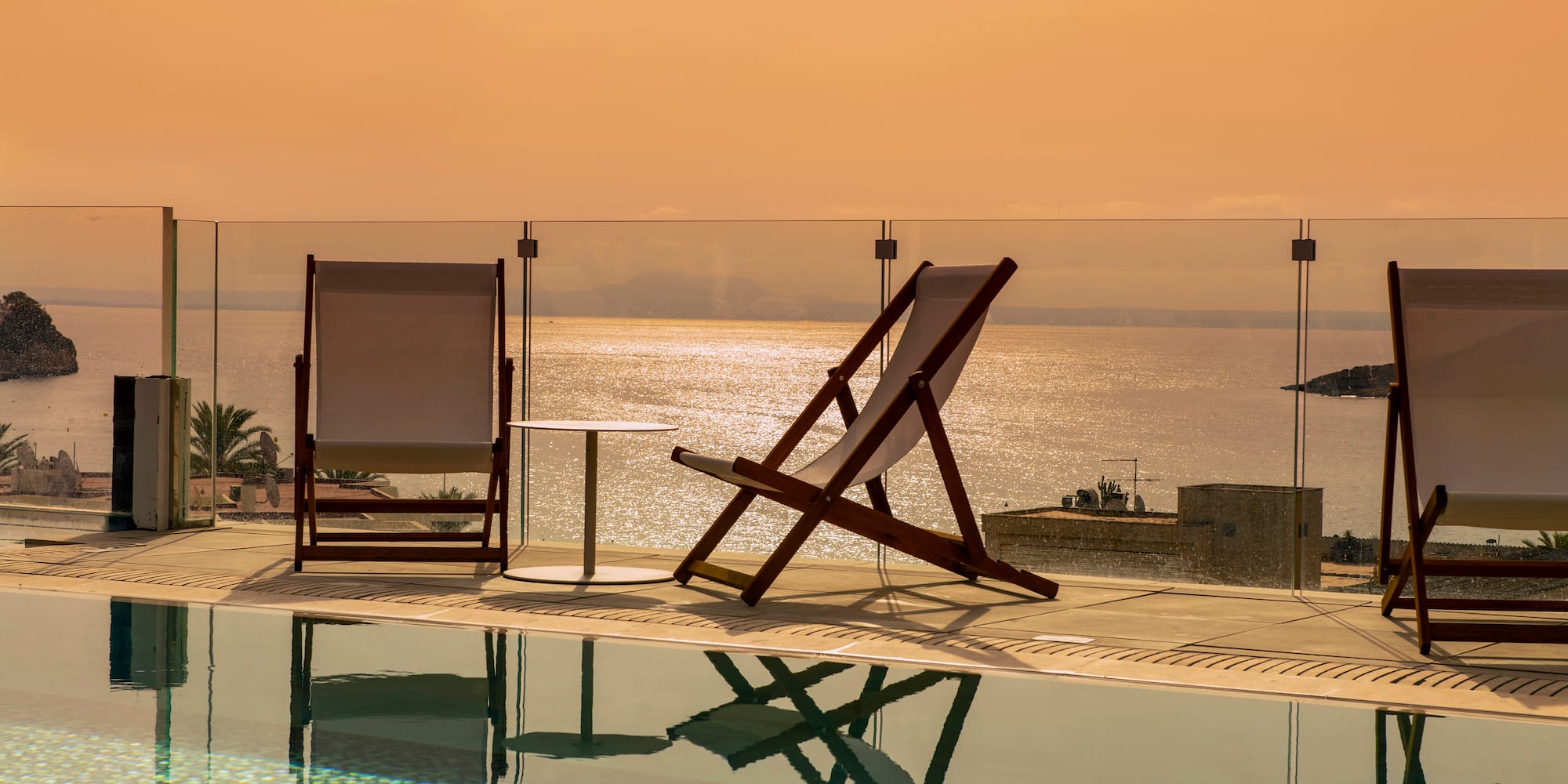 a chair and a table by a pool