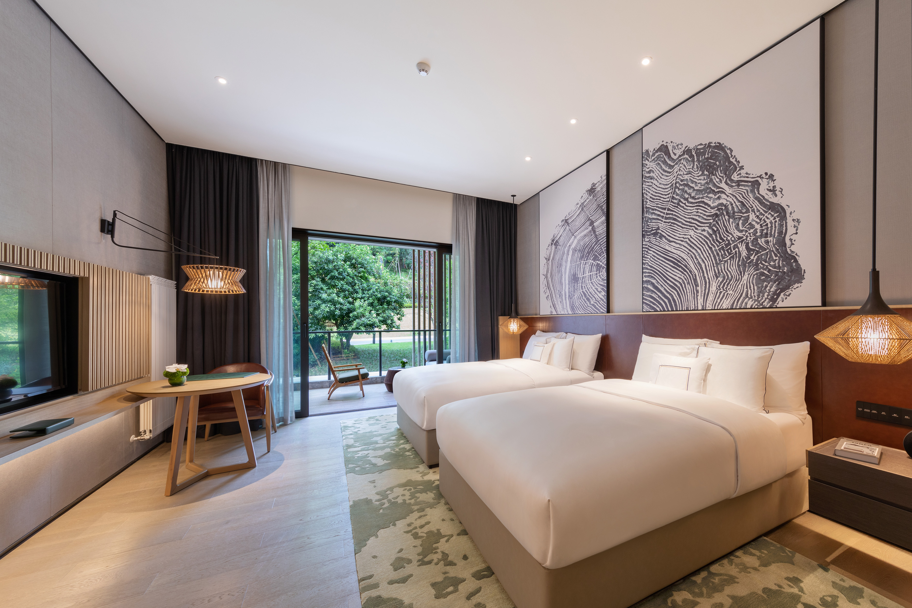 Modern hotel room with twin beds, nature view balcony, and contemporary design.