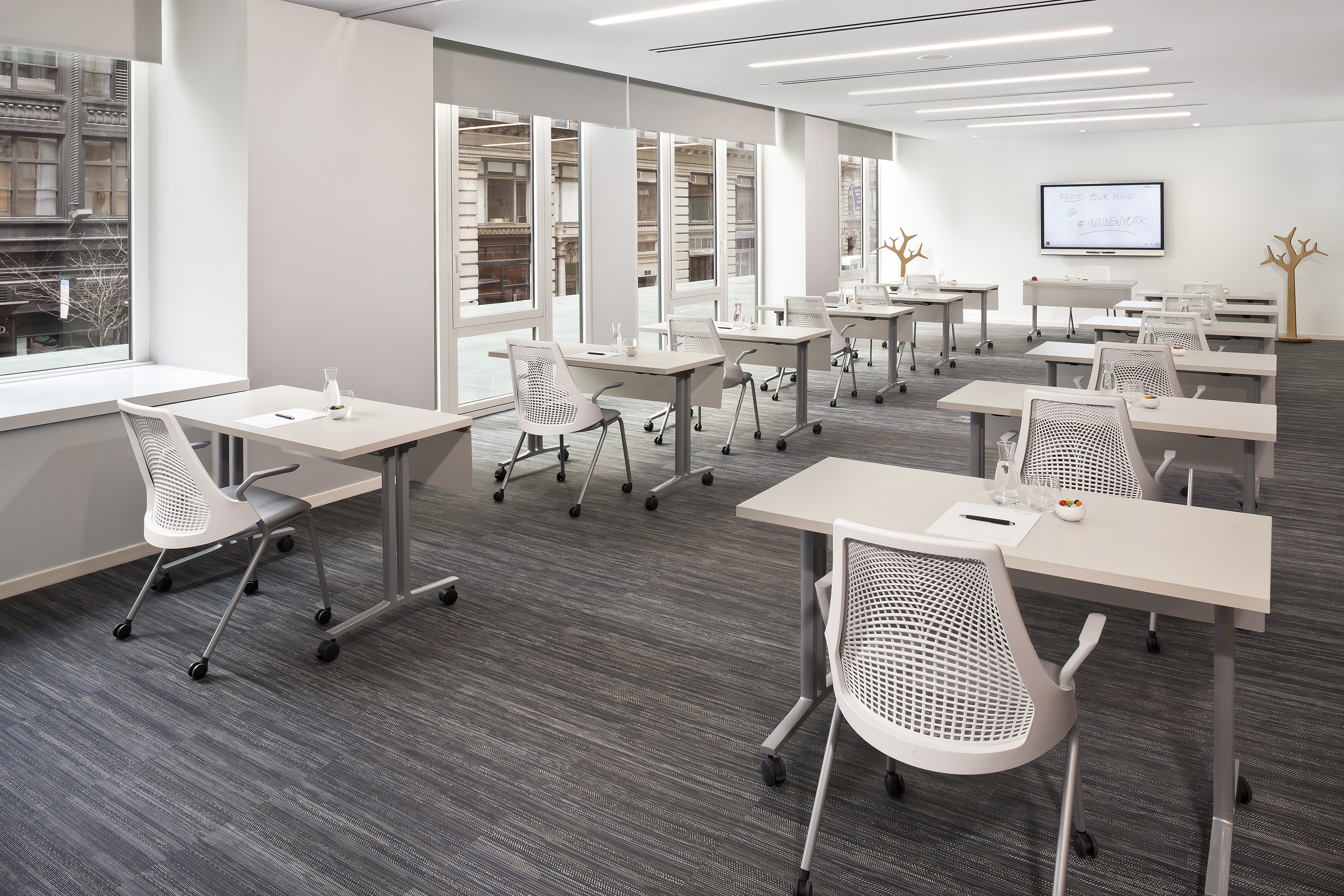 Flexible training room with modular tables, ergonomic chairs, and whiteboard.
